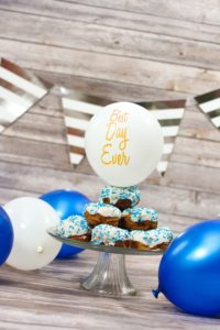 cupcakes on platter with blue and white balloons around them