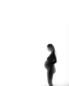 Silhouette of a pregnant person standing and facing sideways against a white background.